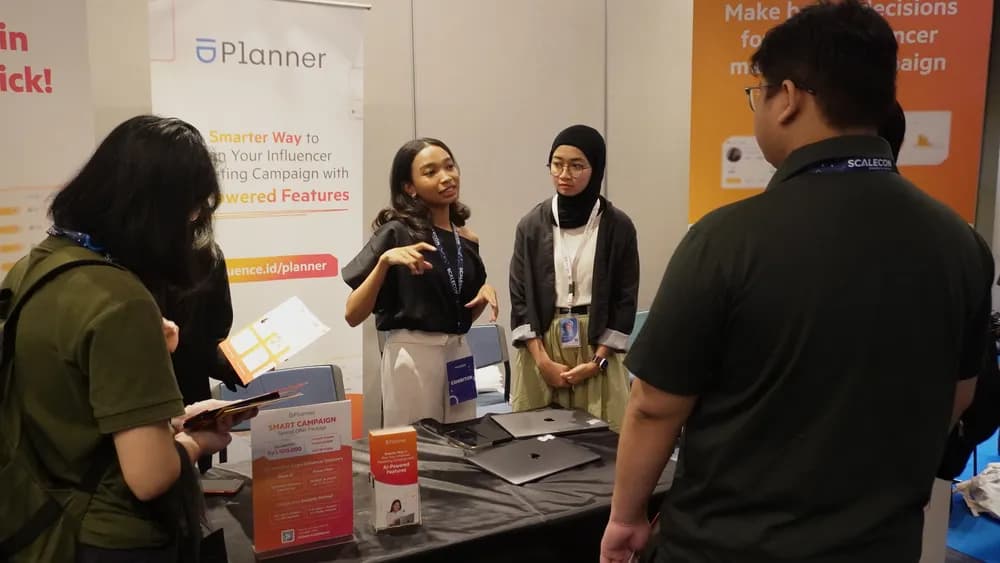 An exhibitor demonstrating a product to attendees at a SCALECON Jakarta 2025 booth