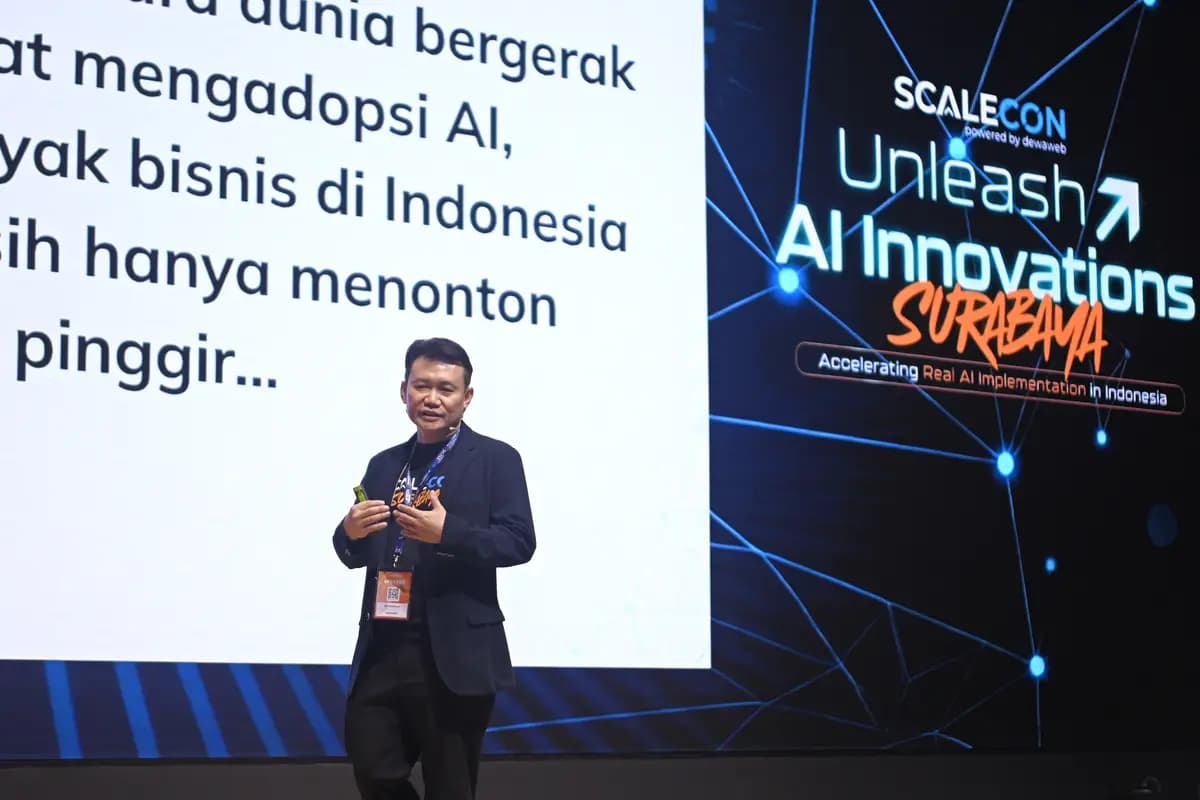 A speaker arguing that many Indonesian businesses are still watching AI adoption from the sidelines, at SCALECON Surabaya 2026