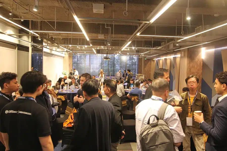 Attendees standing in groups with drinks between sessions at a previous SCALECON